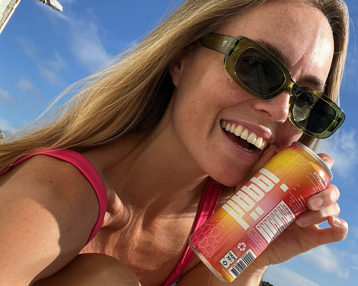 Smiling girl holding a can of hÄppi prebiotic soda, enjoying a refreshing drink that boosts mood and supports gut health