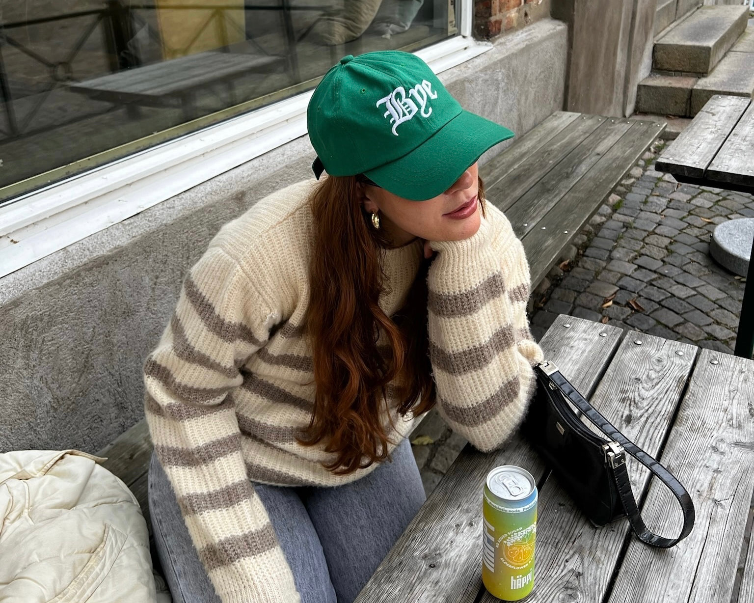 A cozy autumn moment: enjoying a häppi prebiotic soda at an outdoor café, perfect for boosting wellness with natural prebiotics this season.